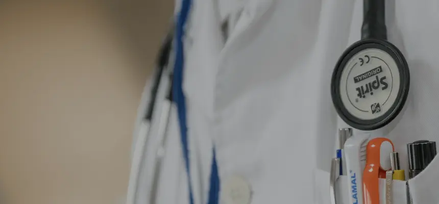 Close up of a doctors coat with front-pocket pens and stethoscope